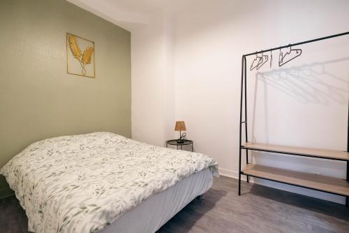 a small bedroom with a bed and a shelf at Verdant Oasis - proche du centre - Wifi gratuit - parking à proximité in Lourdes