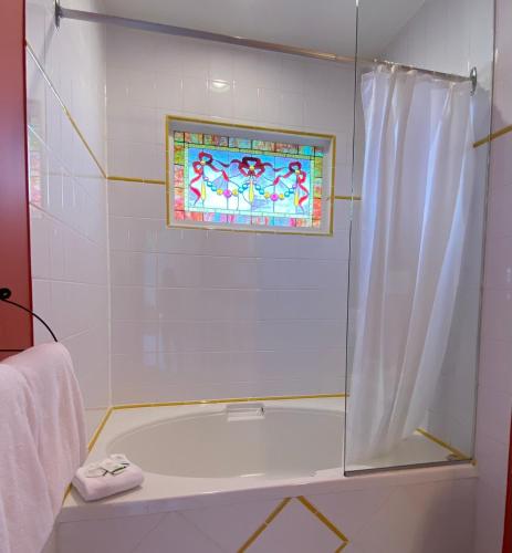 a bathroom with a tub and a stained glass window at The Inn at Tough City in Tofino