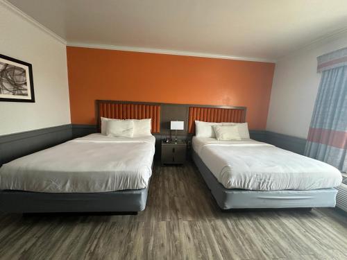 a hotel room with two beds and a table with a lamp at Inn at Mountainview in Greensburg