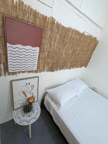 a small bedroom with a bed and a table at Hostel Los Pargos in Río Sequito