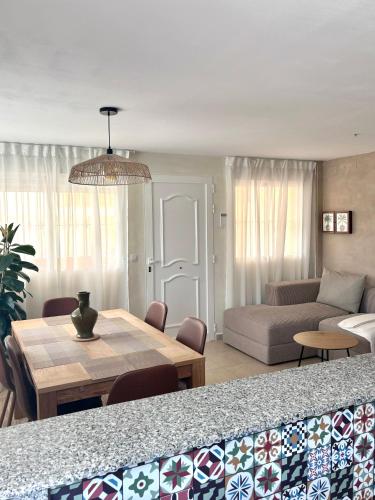 a living room with a table and a couch at Playa de Miramar - 3 Min Walk to the Beach, Family-Friendly, Near Gandia in Miramar