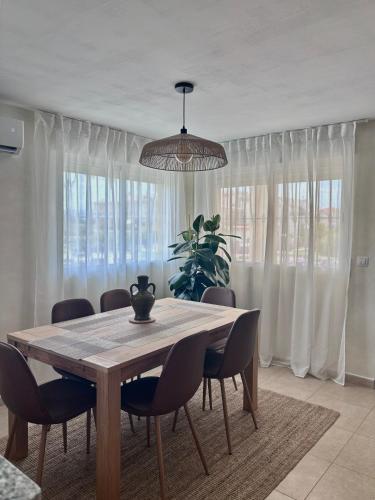 a dining room table with chairs and a potted plant at Playa de Miramar - 3 Min Walk to the Beach, Family-Friendly, Near Gandia in Miramar