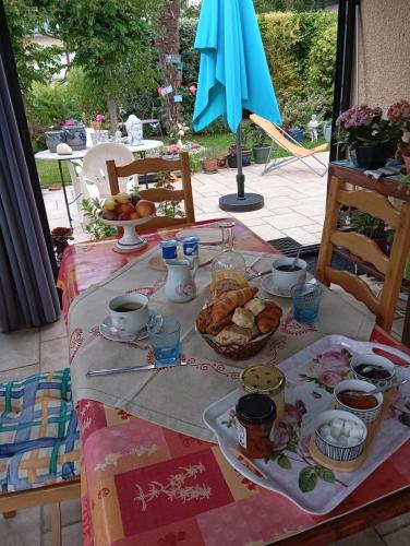 une table avec une assiette de nourriture et un parapluie dans l'établissement la pinède, à Agon-Coutainville