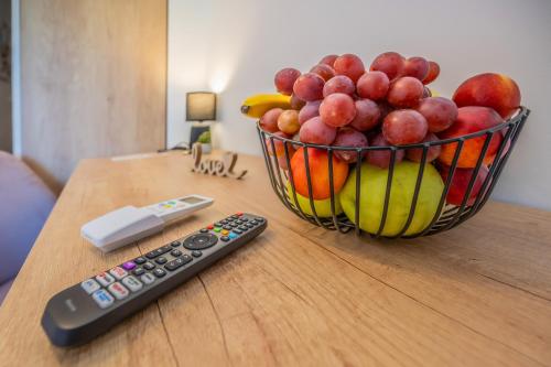 a bowl of fruit and a remote control on a table at Apartment & rooms Vila Toplissa in Varaždinske Toplice