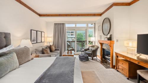 a bedroom with a bed and a living room at 374 Lodge At Spruce Peak Ski In Ski In Ski Out King Studio By Stowe Mountain Rentals in Stowe