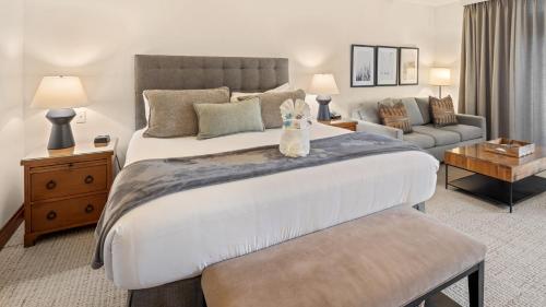 a bedroom with a large bed and a living room at 374 Lodge At Spruce Peak Ski In Ski In Ski Out King Studio By Stowe Mountain Rentals in Stowe