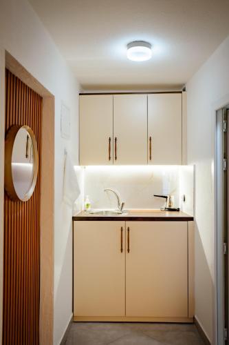 a bathroom with a sink and white cabinets at Duam Apartments in Prizren