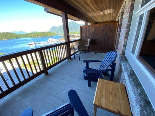 a balcony with chairs and tables and a view of the water at The Inn at Tough City in Tofino