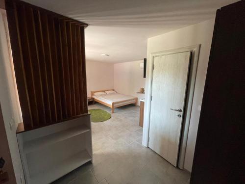 a hallway with a door and a room with a couch at Apartmani Morava 54 in Kočino Selo