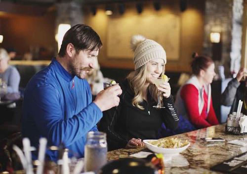 a man and a woman eating food at a table at Cozy Northstar Village Condo Walk to Lifts 2 Full BA Excellent Location in Truckee