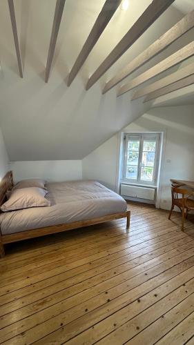 une chambre avec un lit et un parquet dans l'établissement Duplex Familial au Cœur de Dinard, à Dinard