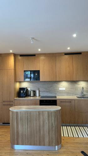 une cuisine avec des armoires en bois et un comptoir dans l'établissement Duplex Familial au Cœur de Dinard, à Dinard