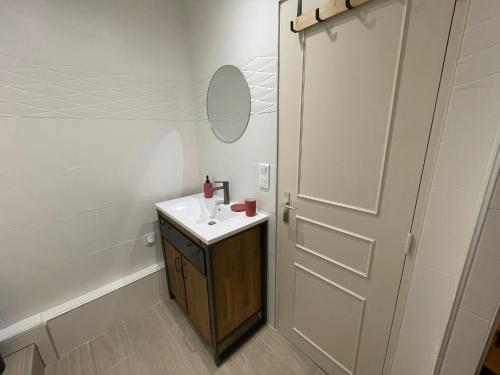 a bathroom with a sink and a mirror and a door at Le Puy élégant - 2 Personnes Le Puy en Velay in Le Puy en Velay