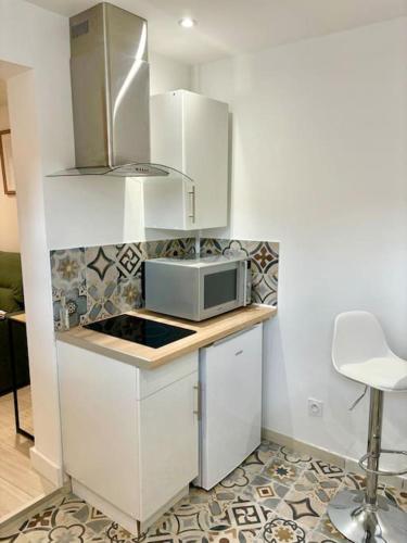 une cuisine avec un comptoir avec un micro-ondes dans l'établissement L'Escobar Troyen, à Troyes