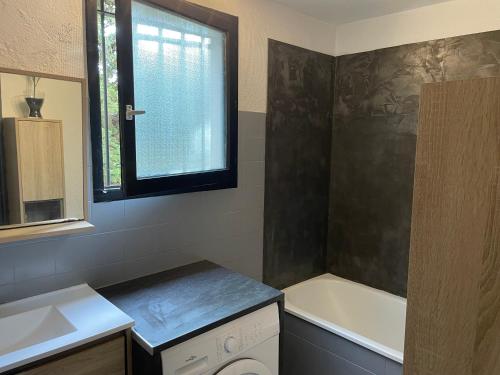 La salle de bains est pourvue d'une baignoire, d'un lavabo et d'une baignoire. dans l'établissement La Cardonille appartement avec patio, à Montpellier