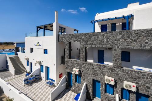 a view of the side of a building with blue windows at Honeymoon Beach Studios in Perivolos