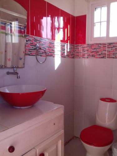 a bathroom with a red sink and a toilet at Cabañas Sherlley in Santa Catalina