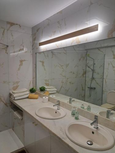 a bathroom with two sinks and a large mirror at Cascais, Vila Bicuda in Cascais