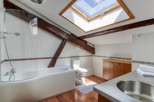 a bathroom with a bath tub and a sink at Séjourner au Château de la Roue Grand appartement in Lissieu