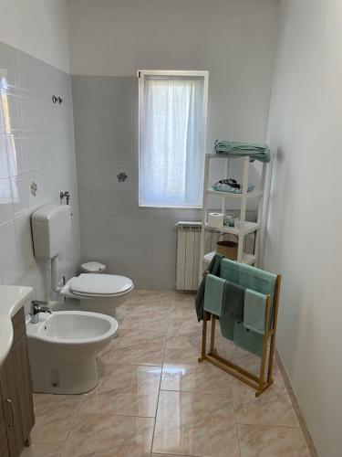 a white bathroom with a toilet and a sink at La casa di Michela in Torino di Sangro