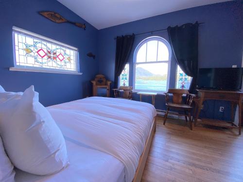 a bedroom with a white bed and a window at The Inn at Tough City in Tofino
