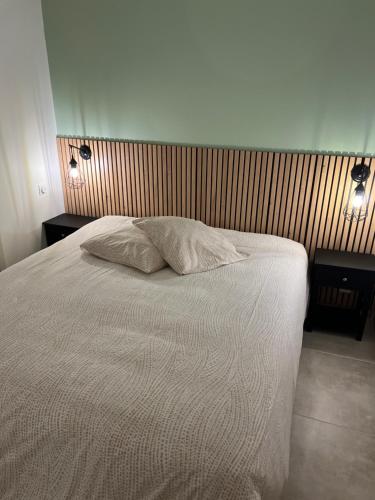 une chambre avec un lit blanc avec deux tables de nuit dans l'établissement Logement Cosy avec jardin, à Cabourg