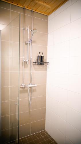 a shower with a glass door in a bathroom at C&C Studio - Comfy Nest Near Airport & City Access in Vantaa