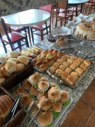 a table topped with lots of different types of bread and pastries at Alvorada Palace Hotel de Poços in Poços de Caldas