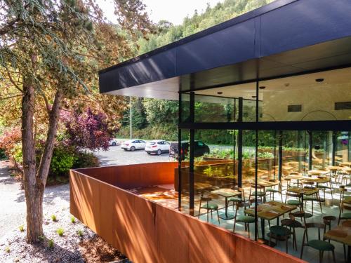 a restaurant with tables and chairs outside of a building at Hostellerie La Claire Fontaine, Logis hôtels & Spa in La Roche-en-Ardenne