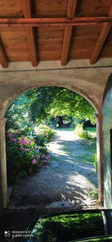 a view of a garden through a stone archway at Casale del Cantico in Brenta