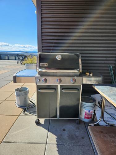 a grill sitting on a patio next to a table at Queen Anne Abode - 1 Block from CPA! - Free Parking! in Seattle