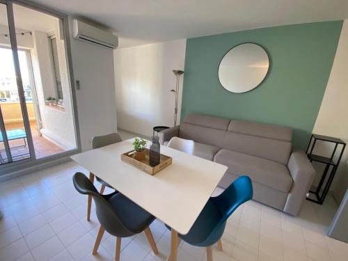 un salon avec une table et un canapé dans l'établissement Studio cabine loggia et terrasse secteur prisé des falaises, au Cap d'Agde