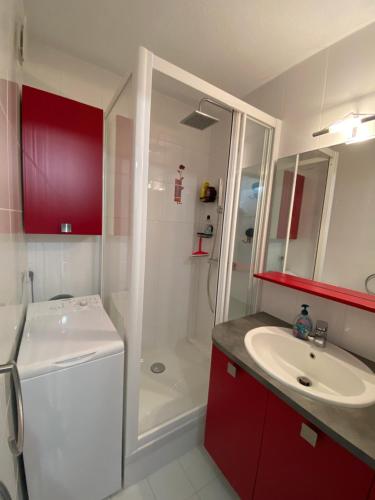 une salle de bain avec un lavabo blanc et une douche dans l'établissement Studio cabine loggia et terrasse secteur prisé des falaises, au Cap d'Agde
