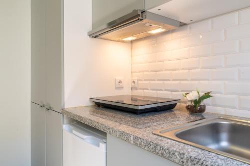 una cucina con un lavello e un piano di lavoro di Oporto Seaside Village - Casa Bosque a Matosinhos
