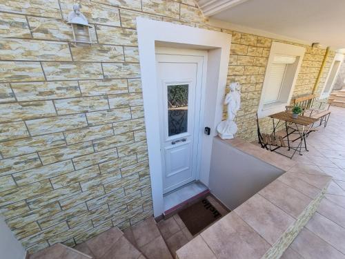a stone wall with a white door and a statue at Prince Apartments in Volissos