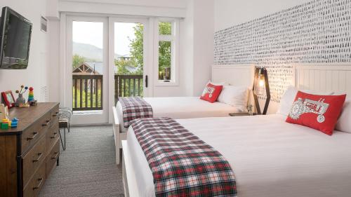 a hotel room with two beds and a television at 1410A Lodge At Spruce Peak Ski In Ski In Ski Out Two Bedroom By Stowe Mountain Rentals in Stowe