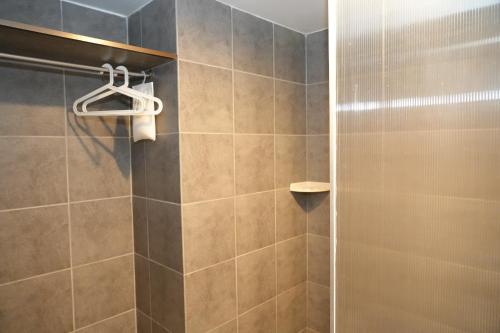 a bathroom with a shower with a glass door at Bkk39 Airport hotel in Ban Khlong Prawet