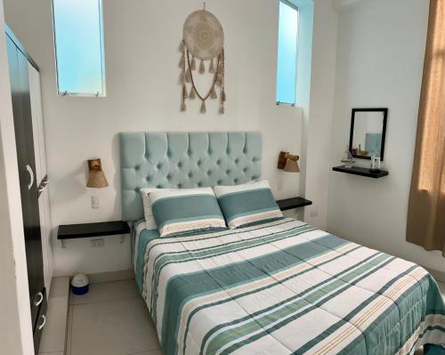 a bedroom with a bed with a blue headboard at Surfer Hostel El Quilla Punta Hermosa in Punta Hermosa