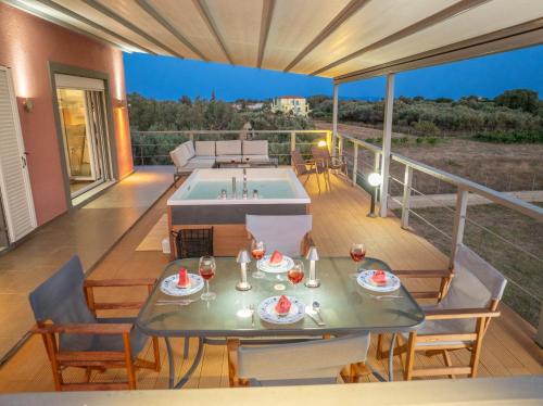 a patio with a table and a pool on a deck at Villa Sorina Kefalonia in Svoronata