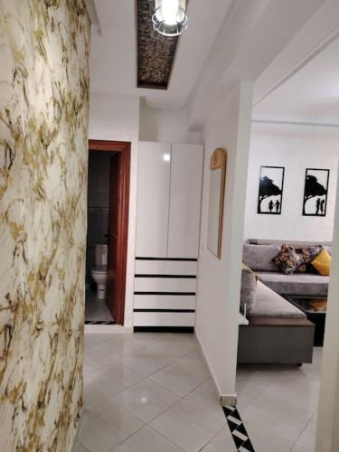 a hallway with a living room with a couch at lumineux, or et ébène Mariés et familles in El Jadida