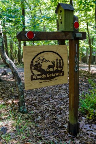 a wooden sign for a woods garden with a bird house at Dog-Friendly A-Frame with Firepit and Fall Foliage in Hedgesville