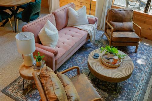 a living room with a pink couch and a table at Dog-Friendly A-Frame with Firepit and Fall Foliage in Hedgesville