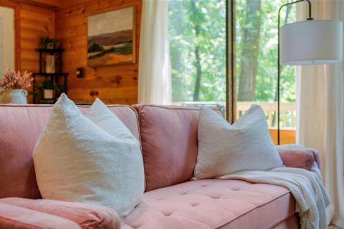 a pink couch with pillows in a living room at Dog-Friendly A-Frame with Firepit and Fall Foliage in Hedgesville