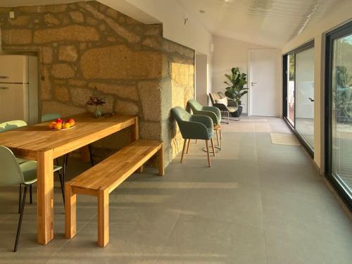 a room with a table and chairs and a stone wall at Casa do Sol - Natureza & Lazer - Serra da Freita in Arouca