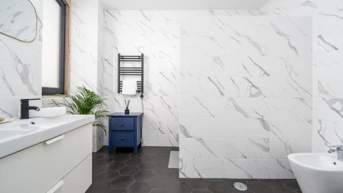 a white bathroom with a sink and a tub at Unique Beautifully Restored Town House in Loulé
