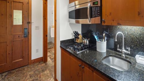 a kitchen with a sink and a counter top at 1206 Lodge At Spruce Peak Ski In Ski In Ski Out King Studio By Stowe Mountain Rentals in Stowe