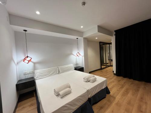 a bedroom with a white bed with two towels on it at New "Villa Albero" Boutique in Torremolinos