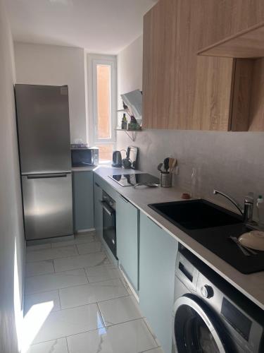 une cuisine avec un réfrigérateur, un évier et un lave-vaisselle dans l'établissement Choose to be central !, à Cannes