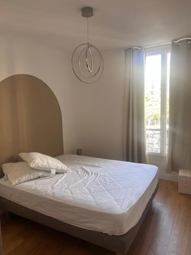 un lit dans une chambre avec une fenêtre dans l'établissement Choose to be central !, à Cannes