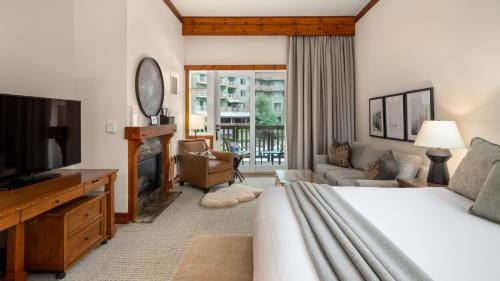 a bedroom with a bed and a tv and a living room at 145 Lodge At Spruce Peak Ski In Ski In Ski Out King Studio By Stowe Mountain Rentals in Stowe